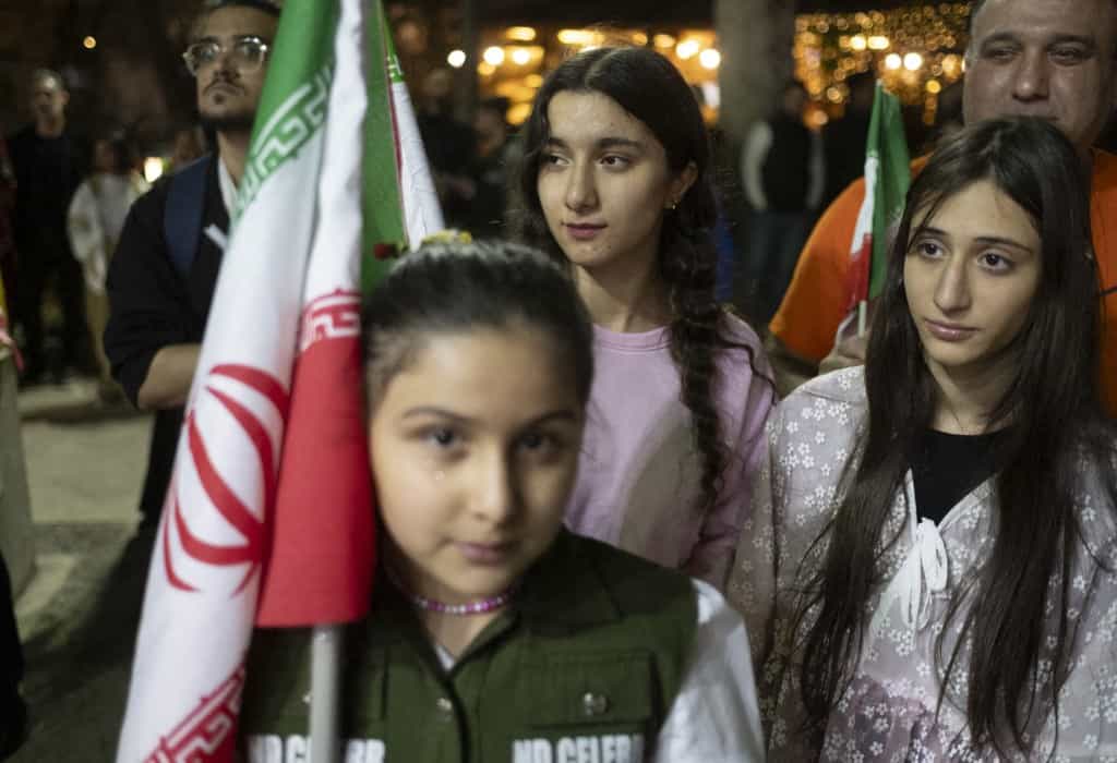 یک جوان طرفدار دولت در طول یک برنامه دولتی مربوط به درگیری ایران با ایالات متحده و اسرائیل، در بیرون موزه سینما در شمال تهران، ایران، در ۱۲ آوریل ۲۰۲۶، در طول آتش‌بس، پرچم ملی را در دست دارد.