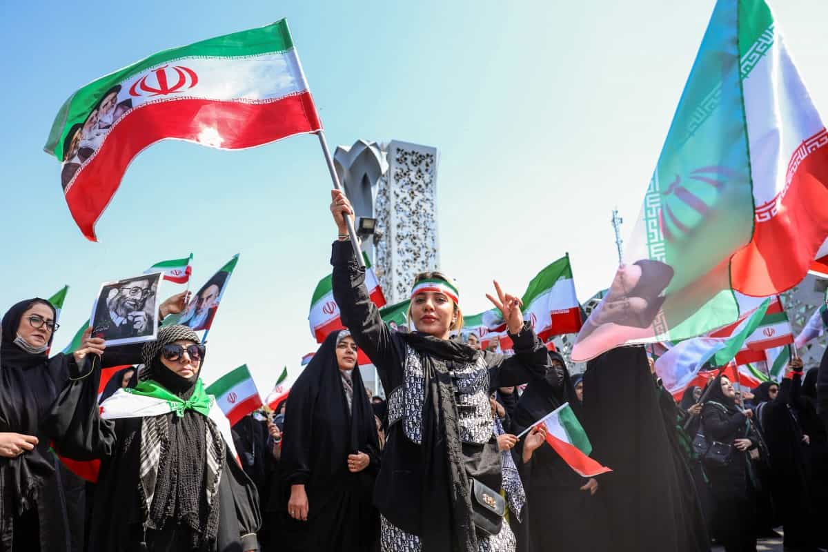 یک زن ایرانی در تظاهراتی با عنوان "دختران قربانی" به یادبود زنانی که در طول جنگ خاورمیانه کشته شدند، در تهران در 28 فروردین 1405 علامت پیروزی را نشان می دهد.