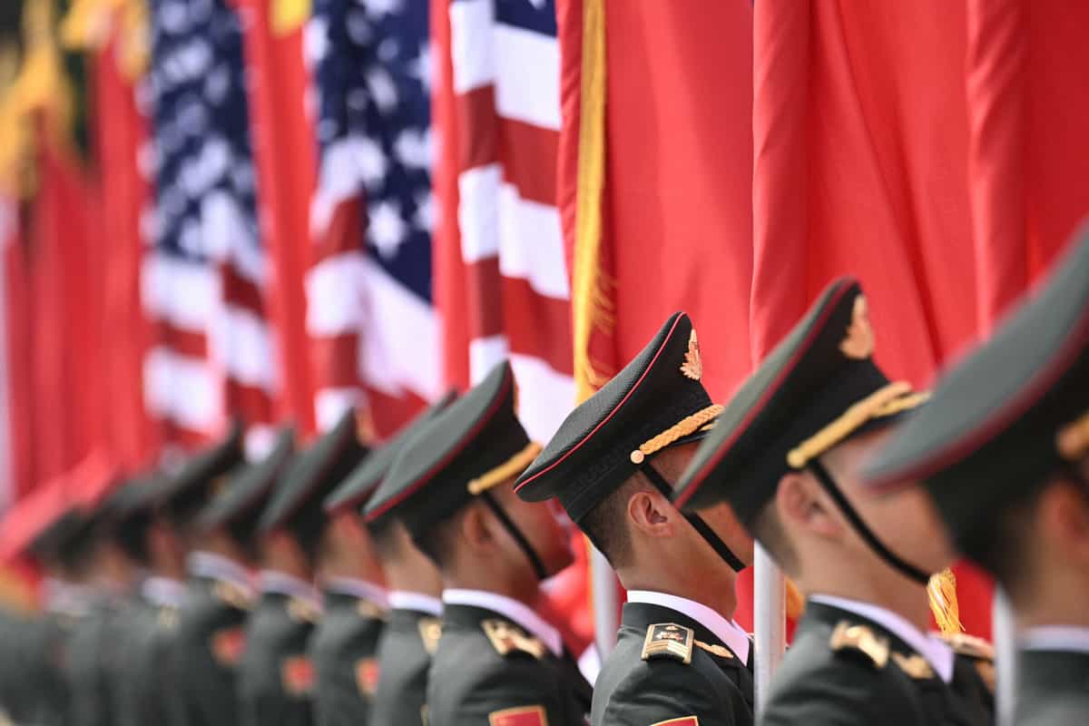 نگهبانان افتخاری ارتش آزادی‌بخش خلق چین (PLA) با پرچم‌های ایالات متحده و چین، پیش از مراسم استقبال از رئیس‌جمهور آمریکا دونالد ترامپ، در مقابل تالار بزرگ خلق در پکن ایستاده‌اند. ۱۴ مه ۲۰۲۶. (عکس از برندن اسمیالوفسکی / AFP)