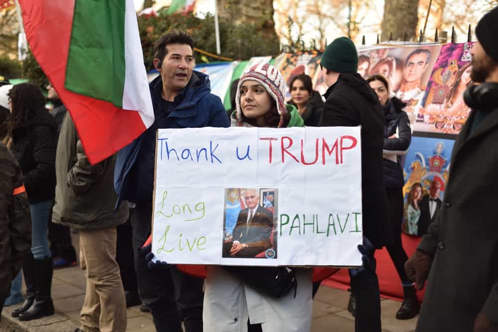 یک معترض پلاکاردی را در دست دارد