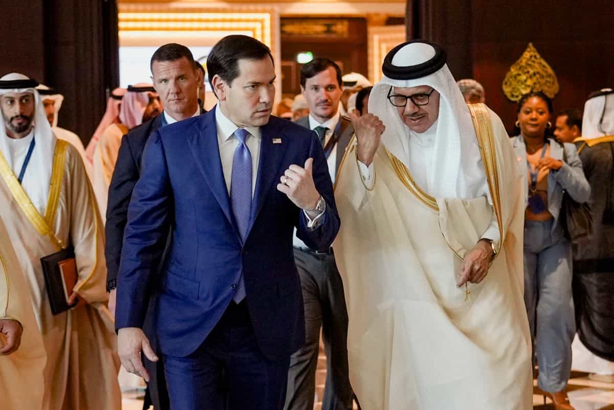 مارکو روبیو و عبداللطیف بن راشد الزیانی در حال قدم زدن با هم گفت‌وگو می‌کنند. مقامات دیگر در اطراف آن‌ها هستند.