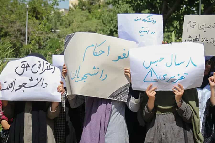 چند دانشجو پلاکاردهایی در اعتراضا به احکام انضباطی در دست دارند