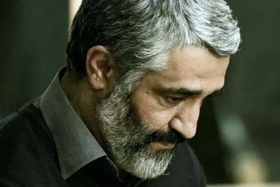 تصویری از چهره پژمان جمشید که سر خود را پایین انداخته است.