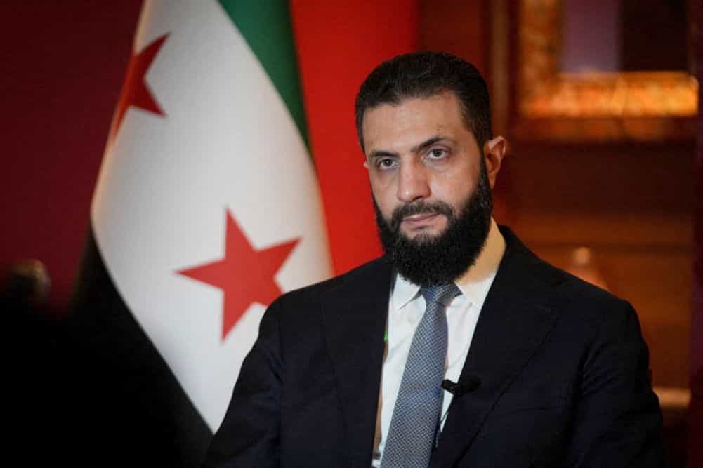 تصویری از چهره احمد الشرع در کنار پرچم سوریه