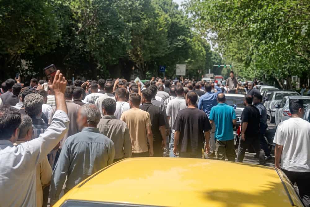 گروهی از رانندگان در تظاهرات خیابانی از پشت سر دیده می‌شوند.
