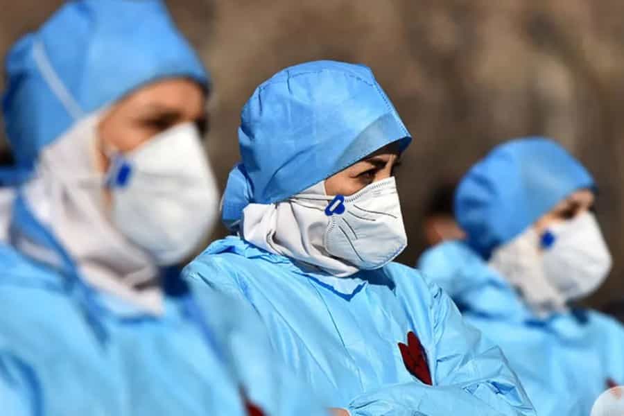 تصویری از چند پرستار که با لباسهای پرستاری در کنار هم ایستادهاند.