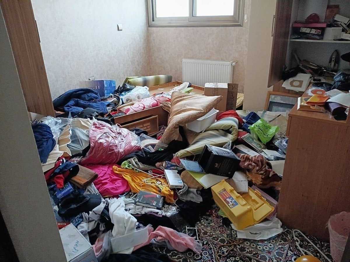 تصویری از یک اتاق شلوغ که تمام وسایل آن روی زمین ریخته است.